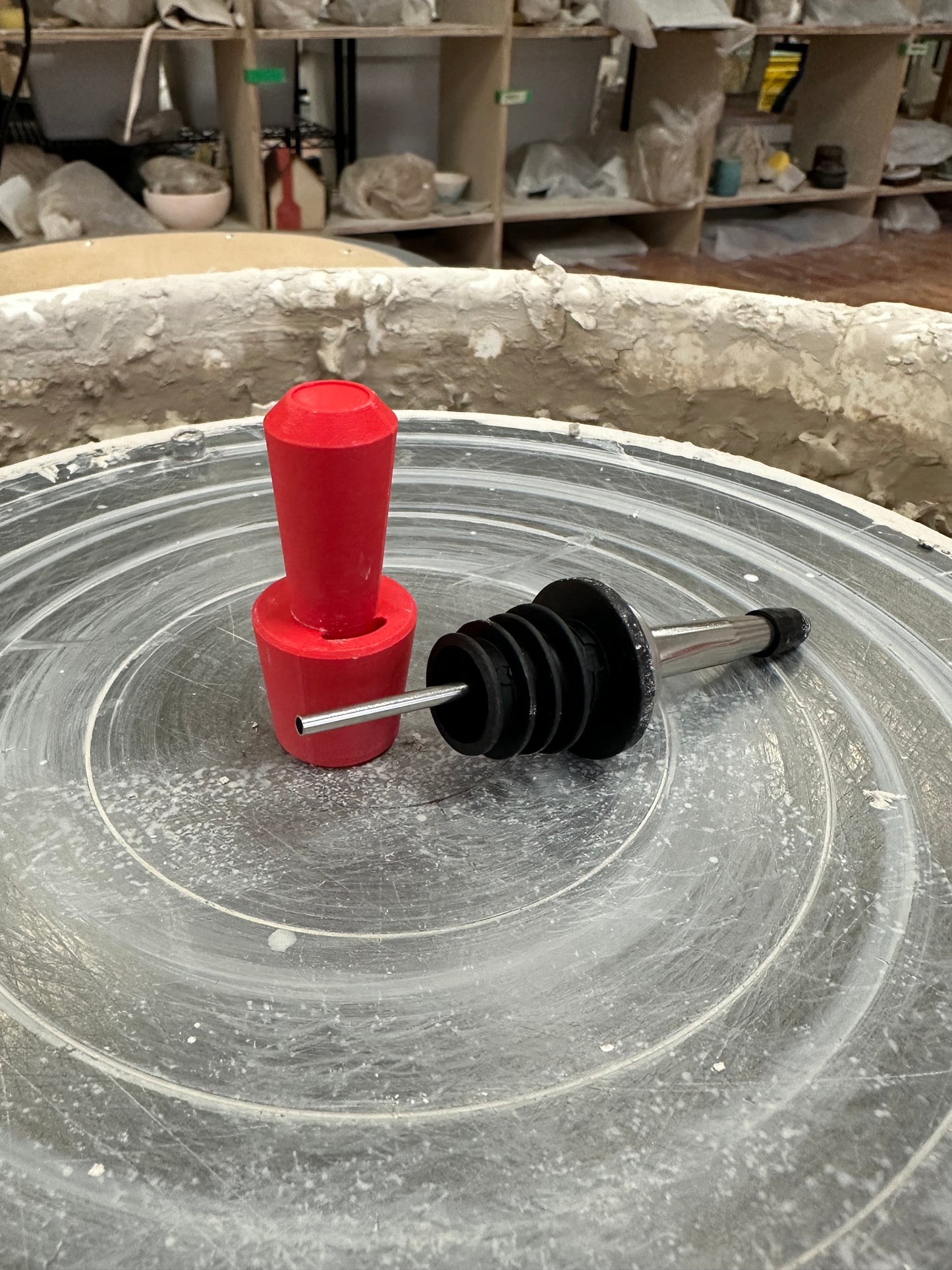 red plastic oil sizer next to an olive oil spout