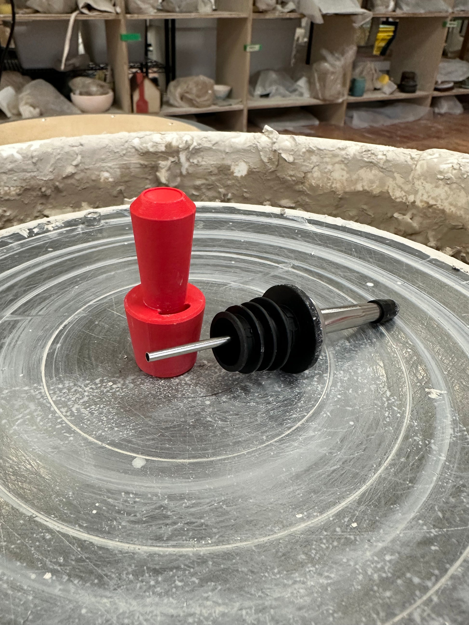red plastic oil sizer next to an olive oil spout